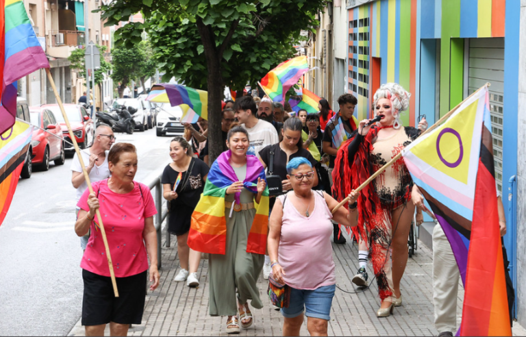 Gent amb banderes arciris fent una rua