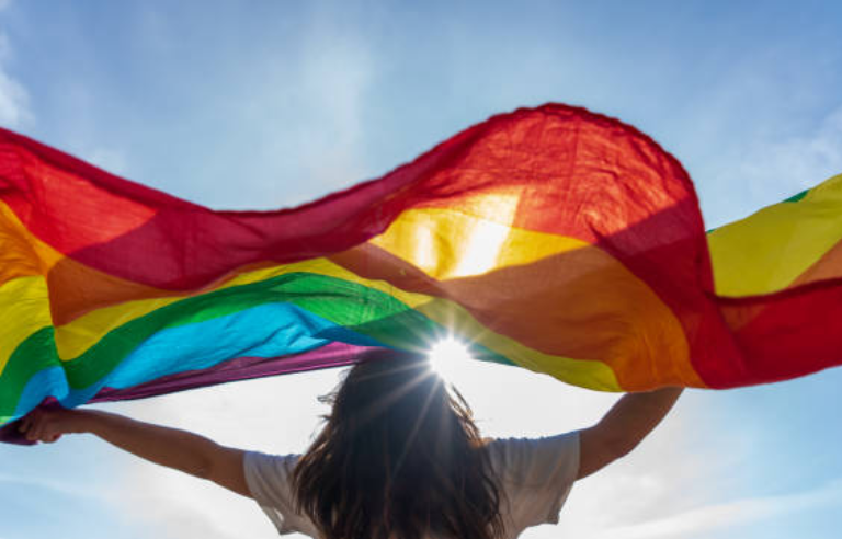 Noia deixant anar al vent la bandera arciris