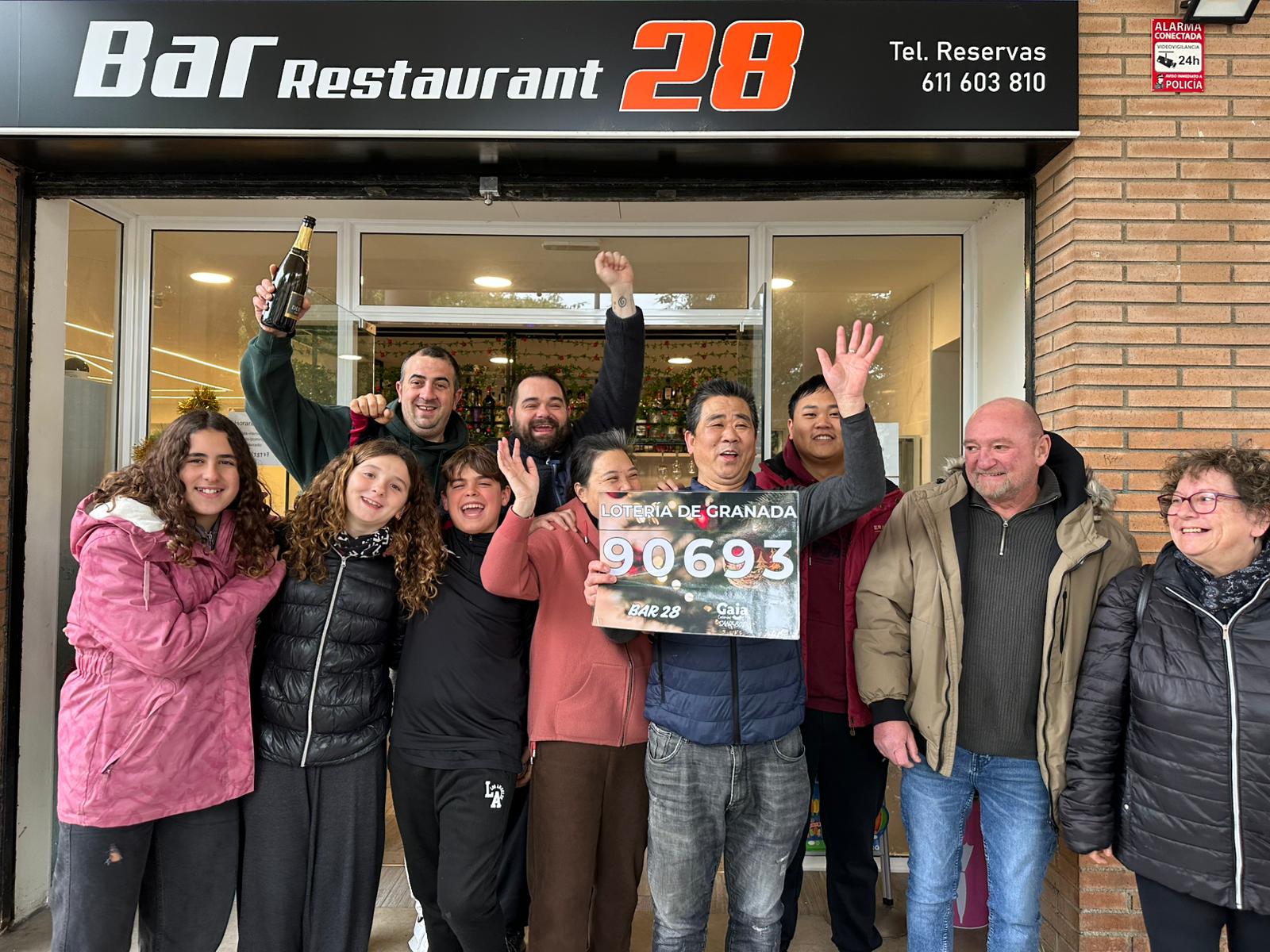 Gent premiada, a la porta de l'establiment on s'ha repartit