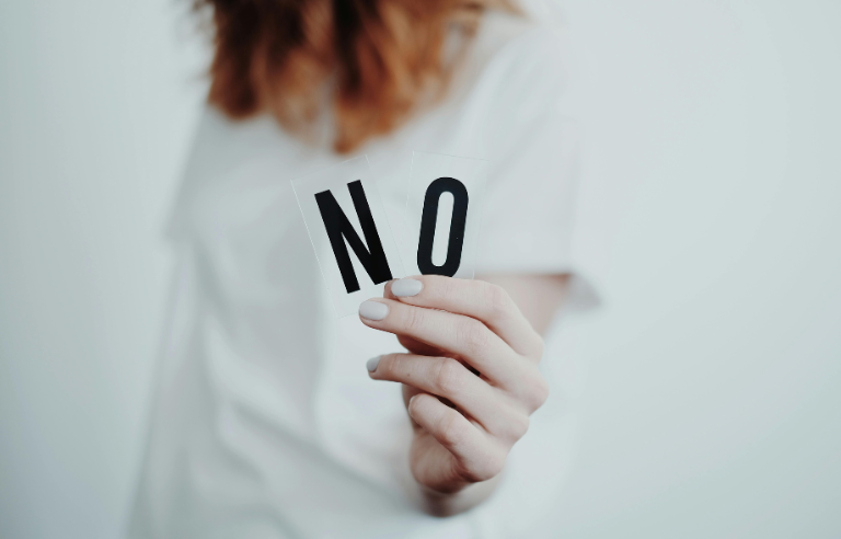 dona que mostra les lletres N i O amb la mà