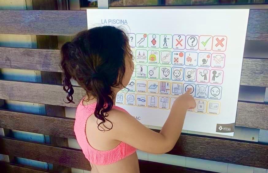 Una nena mira una seqüència de pictogrames en el primer dia de l'activitat