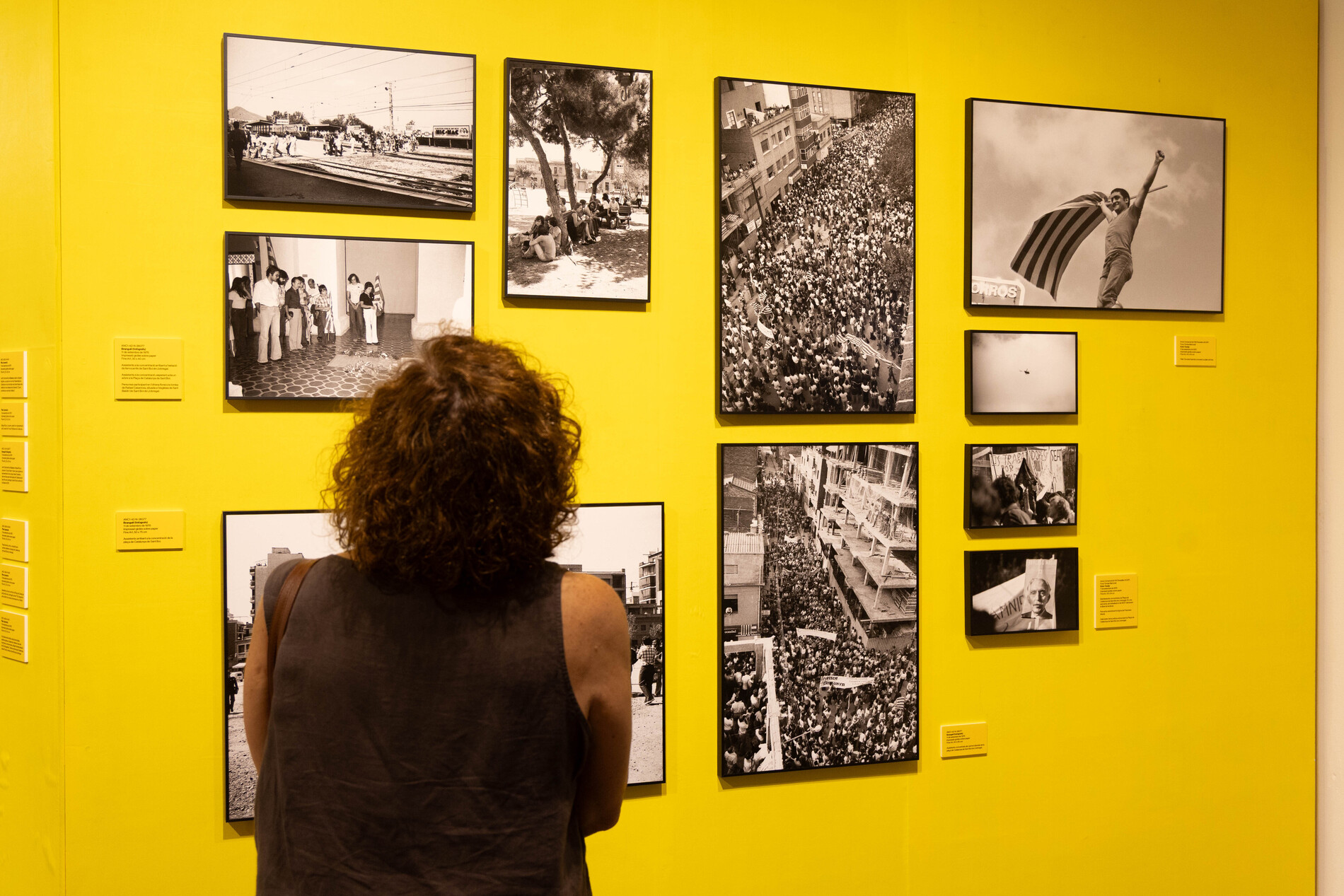 Una dona mira fotografies de l'exposició a una sala del Museu de Sant Boi