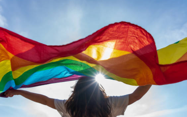 Noia deixant anar al vent la bandera arciris