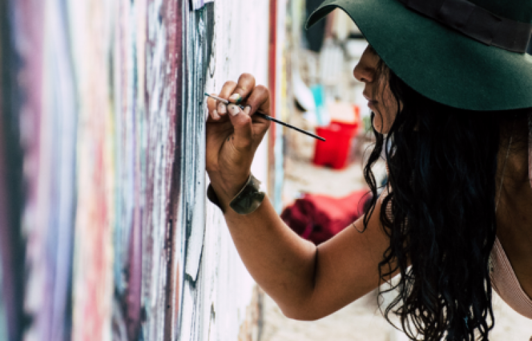 Noia pintant en paret