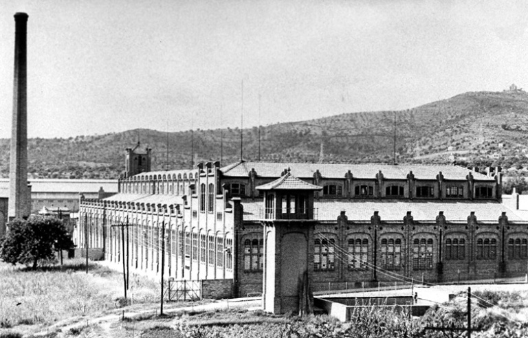 La fàbrica tèxtil de Can Massallera envoltada de garrofers
